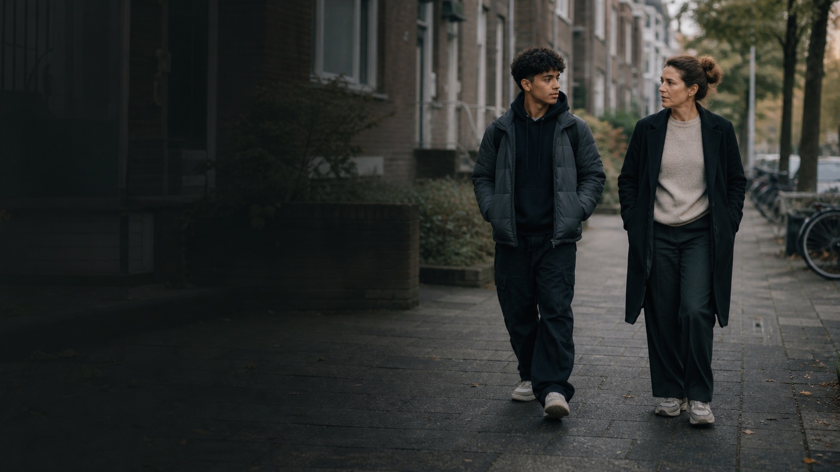Een jongere en een begeleider lopen samen door de straat